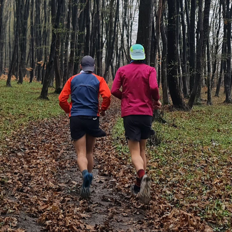 2 people running through a muddy wood