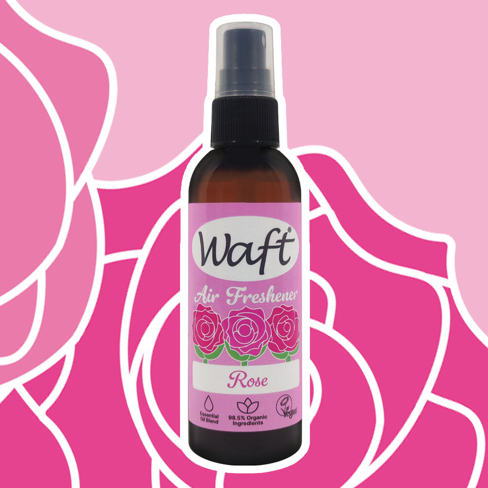 Waft Air Freshener Rose in a brown bottle with pink label on a pink floral background