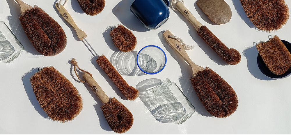 coir brushes from loofco on white background with glasses and blue cup