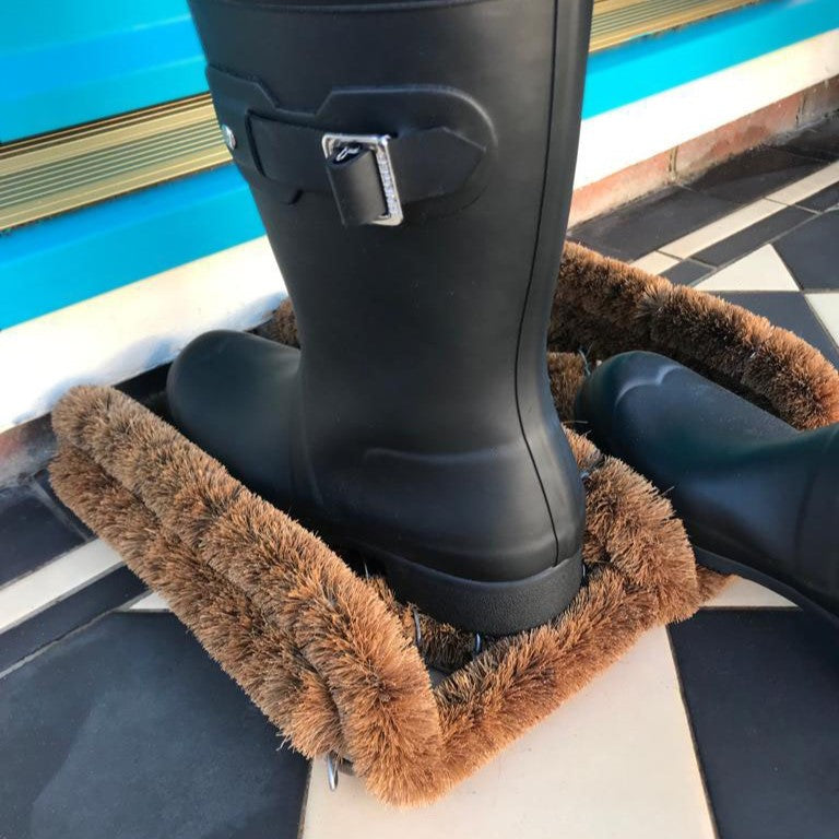 Image of black boot  being cleaned by LoofCo Boot Mat in doorway