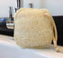 LoofCo Cleaning Pad loofah sponge on a kitchen sink with tap in the background