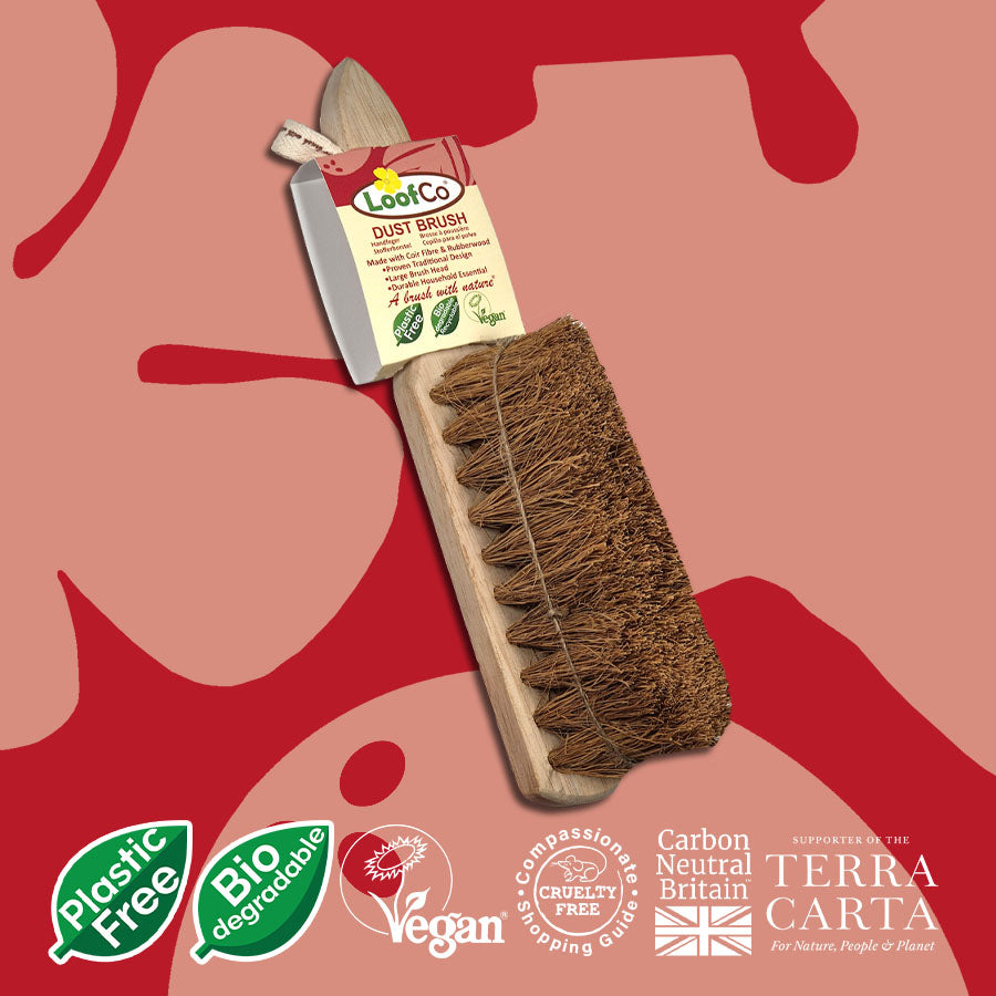 LoofCo Dust brush in packaging on a red and pink abstract background, featuring sustainability logos.