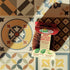 LoofCo mini scrub brush on a tiled surface with decorative tiles in the background