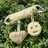 LoofCo Back Scrubber, Smiley face and heart shape against a green leafy background