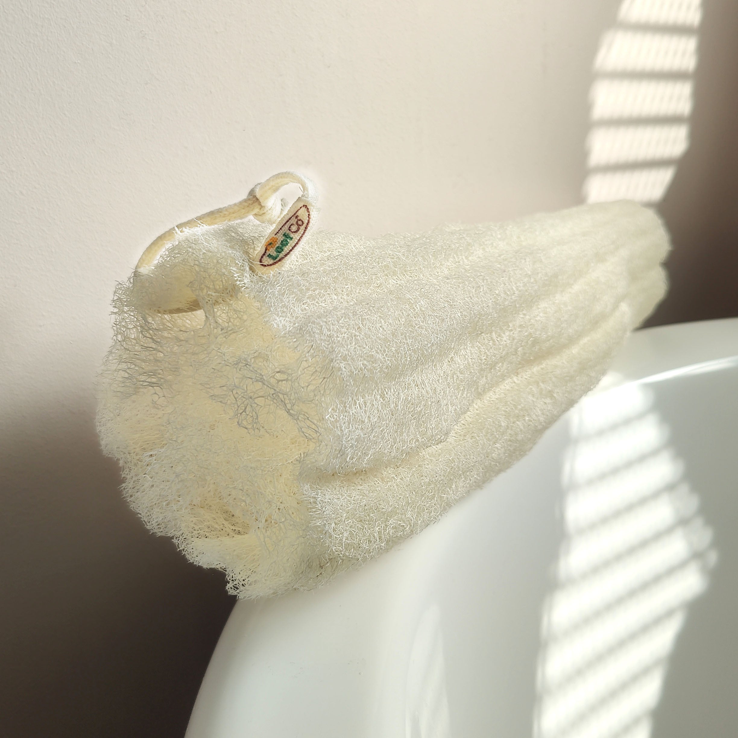 LoofCo Whole loofah on the side of a bath tub 