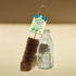 Milk bottle brush with LoofCo label next to a glass bottle on a beige background