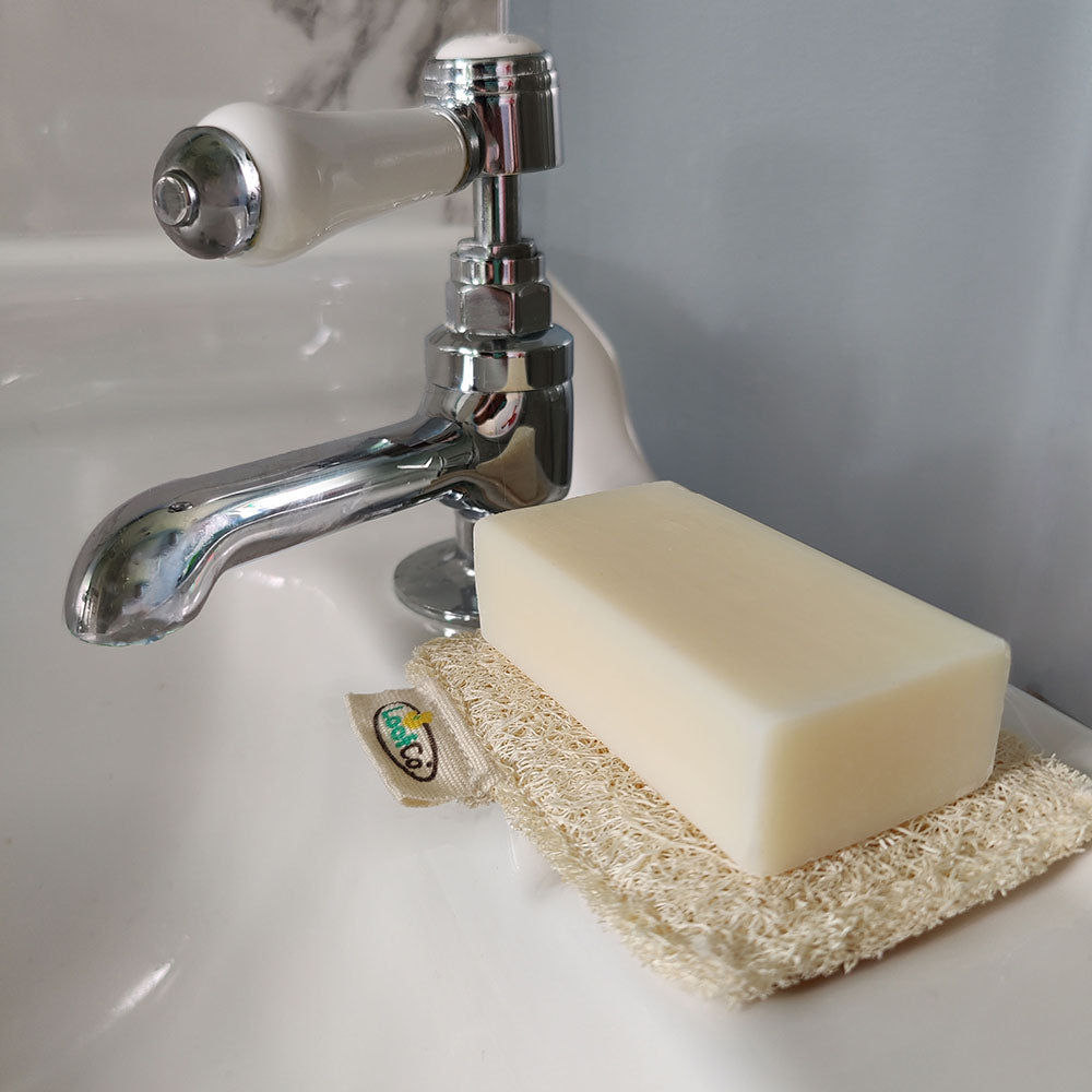 Bar of soap on a LoofCo loofah Soap Rest  next to a sink with a tap
