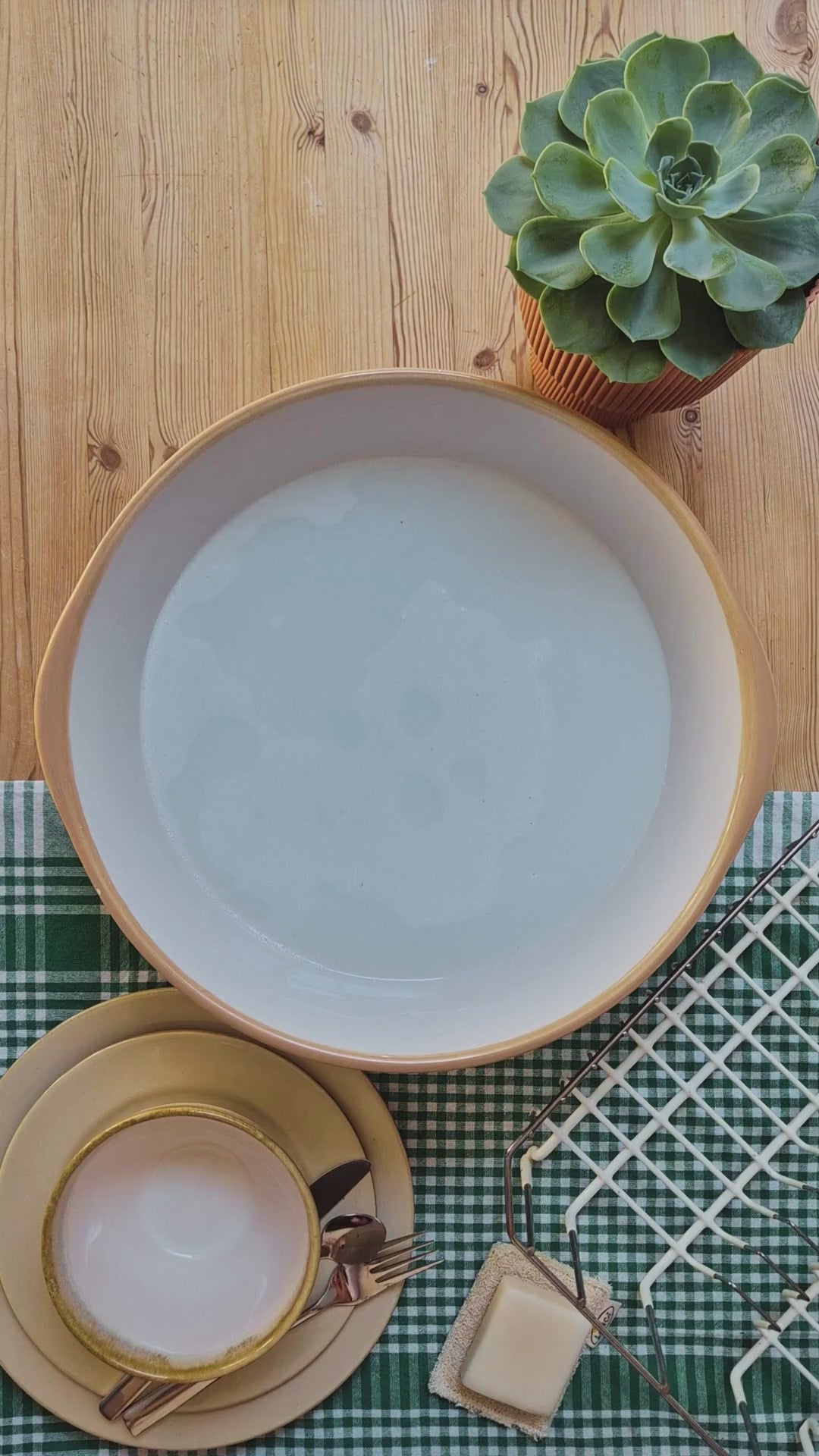 LoofCo coconut coir washing-up brush cleaning a mug, cutlery and plates.