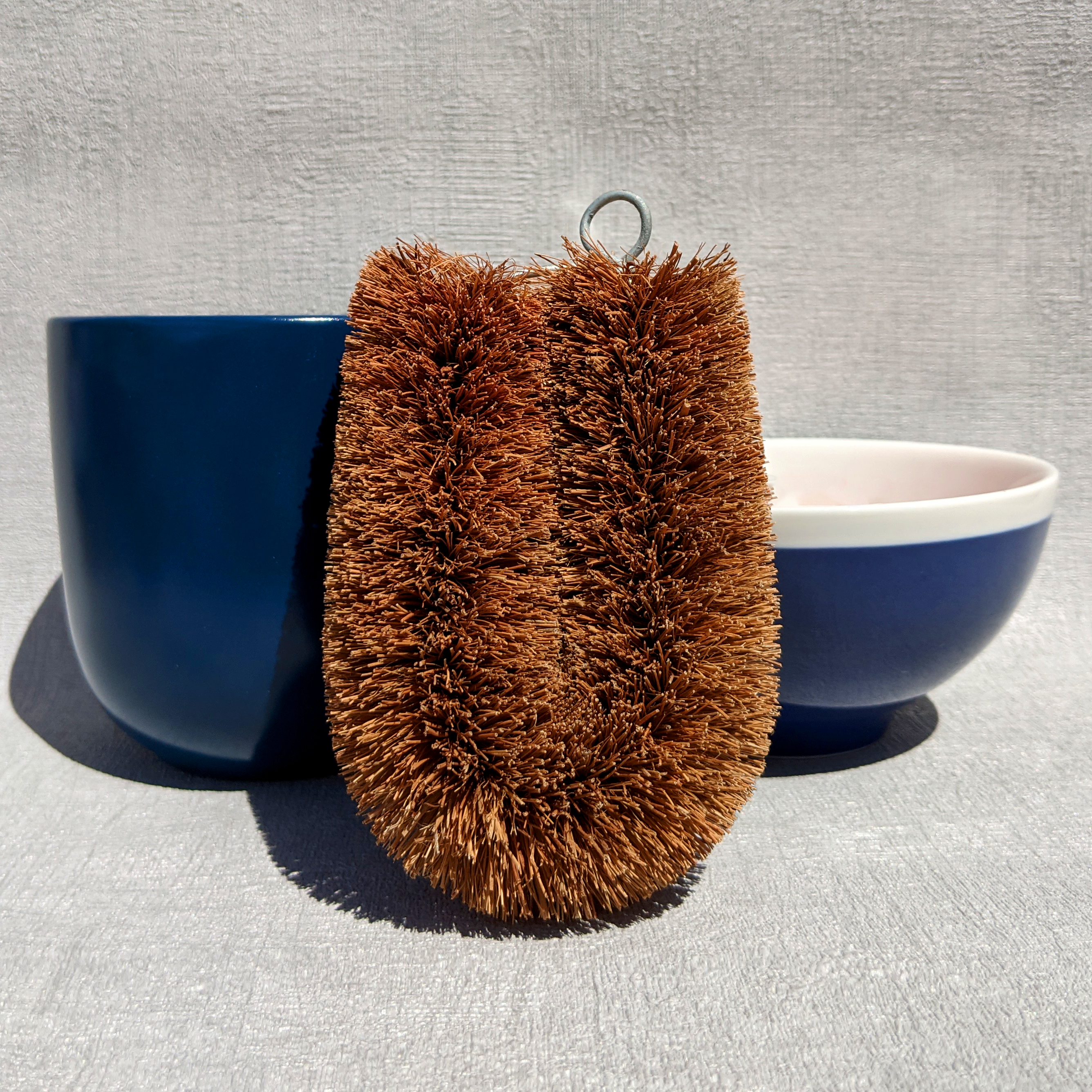 Unlabelled LoofCo washing-Up Brush next to blue cup and bowl