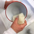 Hand using LoofCo Washing-Up Pad to clean red bowl